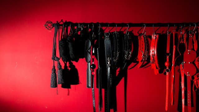 Zestaw akcesoriów BDSM na czerwonym tle – ogłoszenia towarzyskie Warszawa